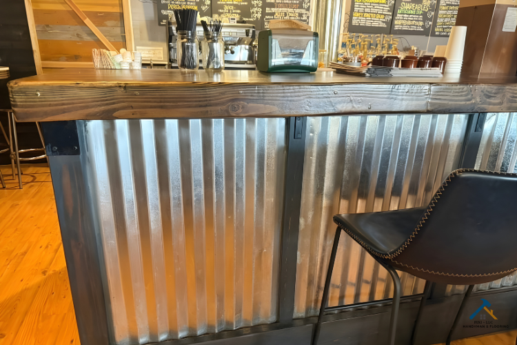 Custom Design for Restaurants and Cafés FIXI LLC Custom café bar counter with corrugated metal panels, wooden top, and modern leather seating, designed by FIXI LLC to enhance restaurant interiors with a rustic-industrial style.